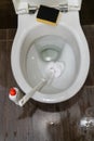 Man hand cleaning toilet with brush