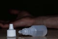 Man hand close up committing suicide by overdosing on medication, pills and bottle beside.