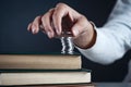 Man hand coins on book on dark background