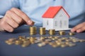 Man hand coins with house model Royalty Free Stock Photo