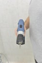 Man hand drills from a cordless drill. Bathroom and tiles.