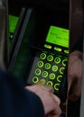 Man hand entering PIN on green illuminated atm machine keypad Royalty Free Stock Photo