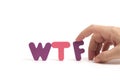 Man hand exposes abbreviation wtf in letters white background. Royalty Free Stock Photo