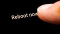 Man hand finger pressing the reboot now computer restart button on a touch screen display rebooting a smartphone, tablet mobile Royalty Free Stock Photo