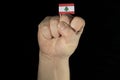 Man hand fist with Lebanese flag isolated on black background Royalty Free Stock Photo