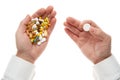 Man hand getting one pill from handful of pills, tablets, vitamins, drugs, capsules isolated on white background. White shirt, Royalty Free Stock Photo