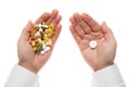 Man hand getting one pill from handful of pills, tablets, vitamins, drugs, capsules isolated on white background. White shirt, Royalty Free Stock Photo