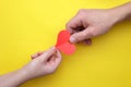 Man hand gives paper heart woman in hand on a yellow background Royalty Free Stock Photo