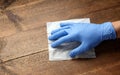 Man hand in glove with wet antibacterial wipe cleaning table Royalty Free Stock Photo