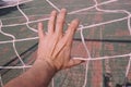 Man hand grabbing the rope net on the street