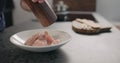 Man hand grind pepper over raw chicken fillet slices to marinate before cooking