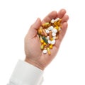 Man hand with handful of pills, tablets, vitamins, drugs, capsules isolated on white background. White shirt, business style. Royalty Free Stock Photo