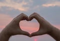 Man hand heart shape in sunset on the beach