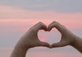 Man hand heart shape in sunset on the beach