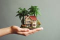 man hand hold miniature house in a palm