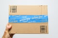 Man hand holding against white Amazon Prime Day cardboard box