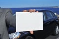 Man hand holding a blank signboard with a car in the background Royalty Free Stock Photo