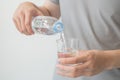 Man hand holding a bottle of water Pouring water into a glass Royalty Free Stock Photo