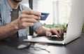 Man hand holding credit card and using laptop in office, Businessman or entrepreneur working on computer, Online shopping concept Royalty Free Stock Photo