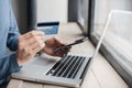 Man hand holding credit card and using smart phone and laptop computer. Businessman or entrepreneur working at office. Royalty Free Stock Photo