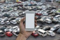 Man hand holding empty screen of smart phone and Outdoor parking