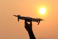 Man hand holding flying drone on sunset background Royalty Free Stock Photo