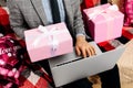 Man hand holding gift box and using laptop at home  shopping online  Valentine's day Royalty Free Stock Photo