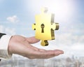 Man hand holding golden puzzle piece with keyhole Royalty Free Stock Photo