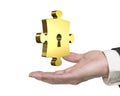 Man hand holding golden puzzle piece with keyhole Royalty Free Stock Photo
