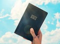 Man hand Holy Bible sky background Royalty Free Stock Photo