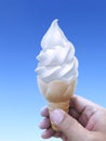 Man hand holding an ice cream cone on background. the blue sky Royalty Free Stock Photo