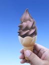 Man hand holding an ice cream cone on background. the blue sky Royalty Free Stock Photo