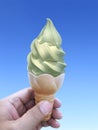 Man hand holding an ice cream cone on background. the blue sky Royalty Free Stock Photo