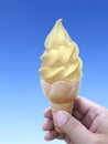 Man hand holding an ice cream cone on background. the blue sky Royalty Free Stock Photo