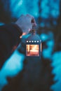 Man hand holding lamp with candle. Winter dark background. Old lantern with candle in a nature