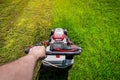 Man hand holding a lawn mower machine to cutting green grass Royalty Free Stock Photo