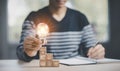 Man hand holding light bulb with Business icon on wood cube and working on desk, Creativity, and innovation are keys to success. C Royalty Free Stock Photo