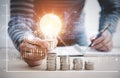 Man hand holding light bulb on coins stack on the wooden table , Saving ideas and investment budget, Creative ideas concept, Stock Royalty Free Stock Photo