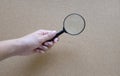 Man hand holding  Magnifying glass  isolate on a brown background Royalty Free Stock Photo