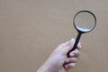 Man hand holding  Magnifying glass  isolate on a brown background Royalty Free Stock Photo