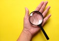 Man hand holding Magnifying glass  on a yellow background Royalty Free Stock Photo