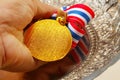 Man hand in holding medal with fabric neck holder ribbon. Royalty Free Stock Photo