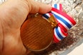 Man hand in holding medal. Royalty Free Stock Photo