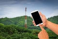 Man hand is holding a modern touch screen phone of mountain in background, Contract mobile towers Royalty Free Stock Photo