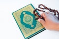 Man hand holding a muslim rosery beads, tasbih with quran asid Royalty Free Stock Photo