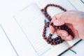 Man hand holding a muslim rosery beads, tasbih with quran asid Royalty Free Stock Photo