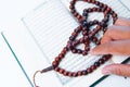 Man hand holding a muslim rosery beads, tasbih with quran asid Royalty Free Stock Photo