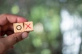 Man hand holding O and X symbol print screen on wooden cube