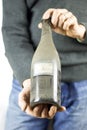 Man hand holding an old wine bottle dusty