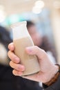 Man hand holding opened glass bottle of coffee